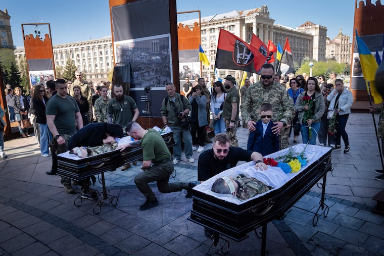 People pay respect at the coffins of Ukrainian servicemen Serhiy Konoval and Taras Petrushun, who were killed in a battle with the Russian troops, during the funeral ceremony in Independence square in Kyiv, Ukraine, on Tuesday, April 9, 2024.