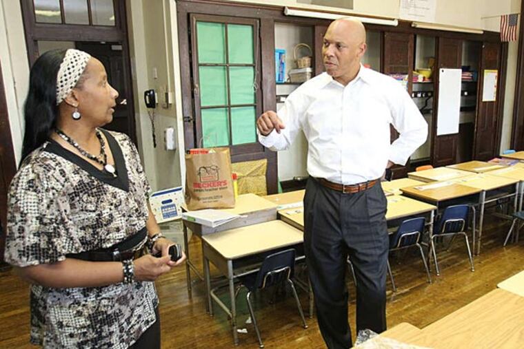 School Superintendent William R. Hite Jr. with principal Cheryl Hackett on a visit last month to S. Weir Mitchell School in Kingsessing. (File photo)