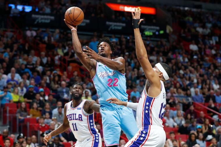 Miami's Jimmy Butler (22), who scored 25 points, goes up for a shot against the 76ers' Tobias Harris (12) and James Ennis III (11) in the first half.