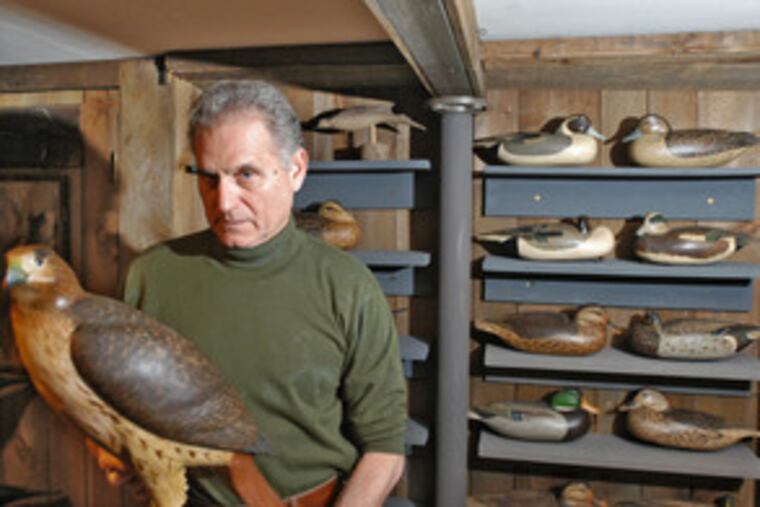 Bob White, who has been carving decoys for about 60 years, displays a carving of a red-tailed hawk in the basement of his Tullytown home. These days, wildfowl decoys are more folk art than practical hunting tool.