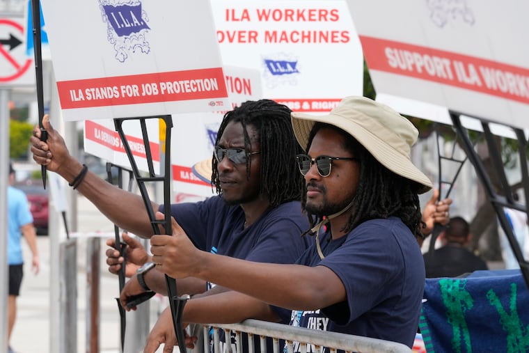 Dockworkers from Port Miami display signs at a picket line in Miami.