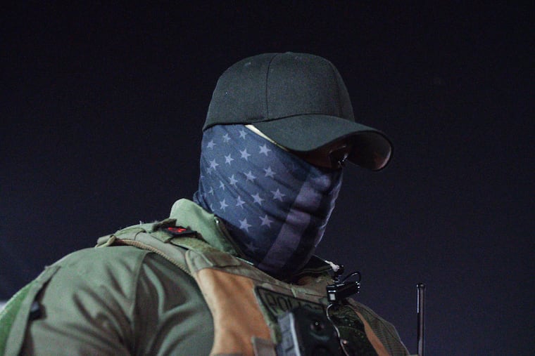 A U.S. Immigration and Customs Enforcement agent stands outside the Delaney Hall Detention Facility during a June protest over federal immigration enforcement raids in Newark.