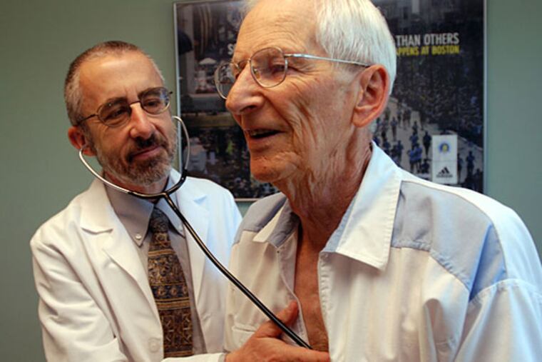 In this June 19, 2012 photo, Dr. Bruce Stowell examines patient Robert Busch at his office in Grants Pass, Ore. Stowell is among many doctors in rural areas who have capped the numbers of Medicare patients they take due to low reimbursement levels. A nationwide shortage of primary care physicians willing to set up practice in rural areas is making the problem worse. (AP Photo/Jeff Barnard)