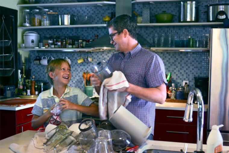 Realtor Christopher Plant , drying dishes with his son Mason, tells perspective buyers "they can't rely on any of the public schools." TOM GRALISH / Staff Photographer