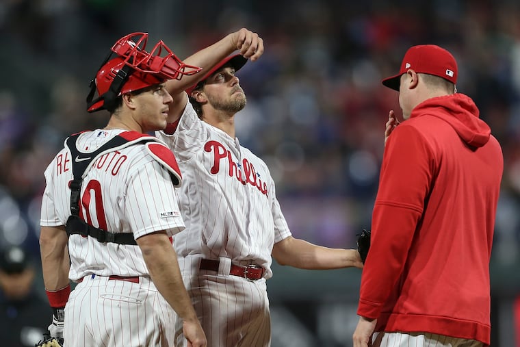 Phillies pitching coach Chris Young, right, has a conversation on the mound with pitcher Aaron Nola and catcher J.T. Realmuto on Monday night at Citizens Bank Park.
