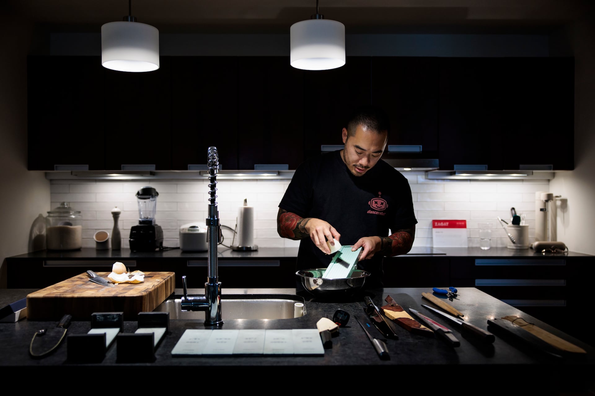 Chef Jesse Ito demonstrates how to use a mandoline in his Center City kitchen. Ito recently moved into the apartment.