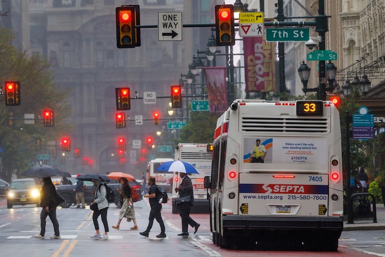 Umbrellas come out on a drizzly morning in Center City. Photograph taken looking west on Market Street from Sixth Street.