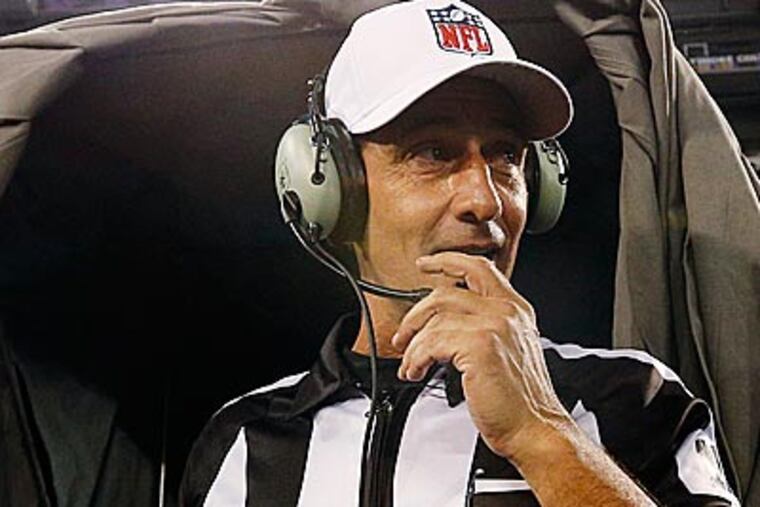 Referee Gene Steratore talks to booth officials before a game between the Baltimore Ravens and Cleveland Browns. (Patrick Semansky/AP)