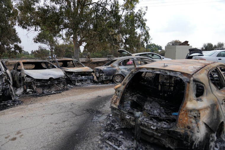 Destroyed cars are seen at the rave party site near the Kibbutz Re'im, close to the Gaza Strip border fence, on Tuesday. Israel's rescue service Zaka said paramedics had recovered at least 260 bodies of people killed in a surprise attack by Hamas militants Saturday.