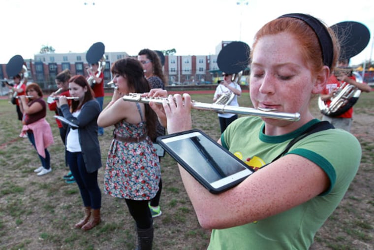 Temple Band flutist Johanna Wiley looks down at her iPad to see the sheet music for the music she is playing during practice on Wednesday. ( MICHAEL BRYANT / Staff Photographer )