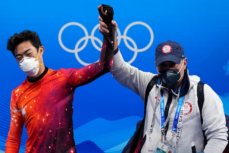 Nathan Chen (left) celebrates with his coach Rafael Arutyunyan after winning the gold medal in the men's free skate program during the figure skating event at the 2022 Winter Olympics.