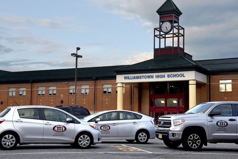 Vehicles from an environmental remediation company are in front of Williamstown High School after schools were closed for mold.