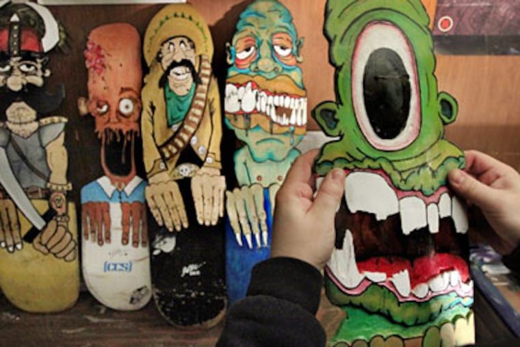 South Philly artist Josh Leach works on one of his creations made of broken boards. (Elizabeth Robertson/Staff)