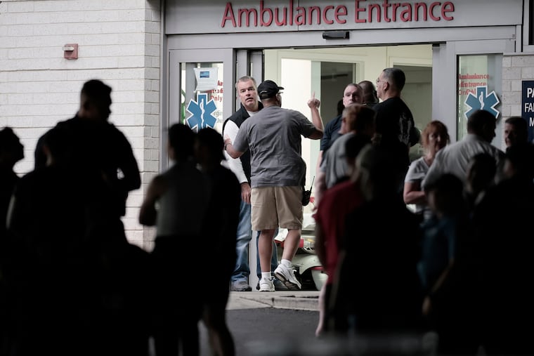 Philadelphia's managing director Adam K. Thiel comes out of the emergency entrance of Penn Presbyterian Medical Center in Philadelphia on Sunday after three officers were wounded in an exchange of gunfire that left a man dead.