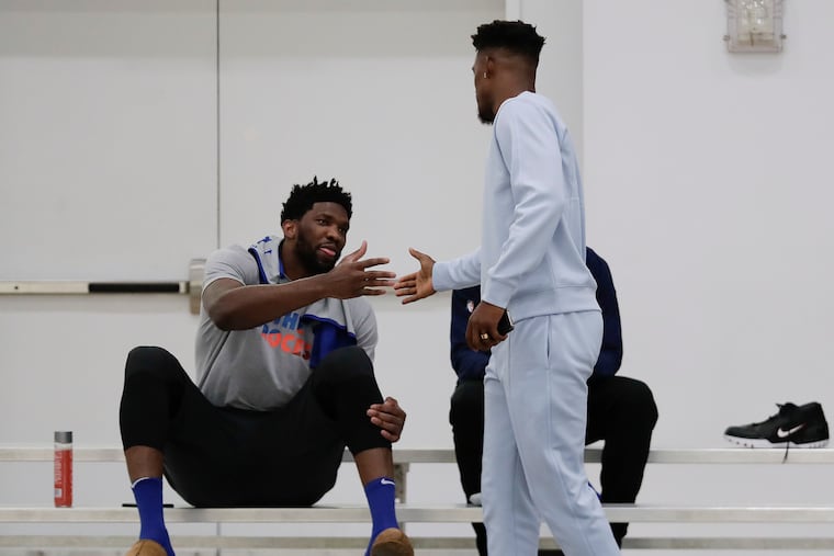 Sixers center Joel Embiid greets teammate guard Jimmy Butler before the start of practice at Basketball City in New York on Friday.