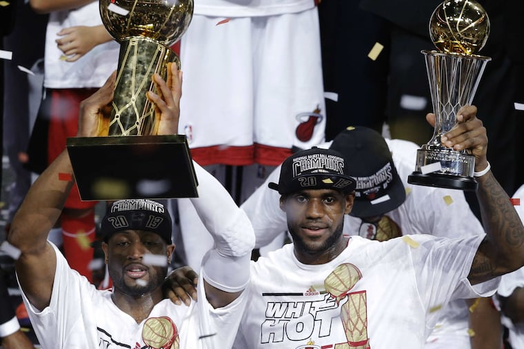 Miami Heat's Dwyane Wade holds the Larry O'Brien NBA Championship Trophy, left, and LeBron James holds the Bill Russell NBA Finals Most Valuable Player Award after Game 7 of the NBA basketball championships.