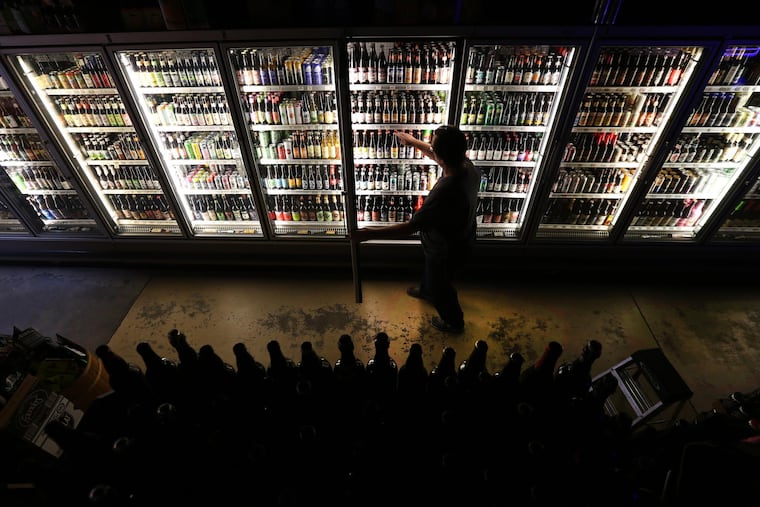 Mike Kellett, owner of Bottle Bar East at 1308 Frankford Avenue, straightens up the beers in his massive display case on February 8, 2016 in Philadelphia, Pa.