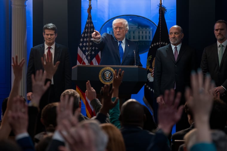 President Donald Trump addresses the Supreme Court's ruling on his tariffs at a news conference at the White House on Friday. Joining him, from left, are Solicitor General D. John Sauer, Commerce Secretary Howard Lutnick, and Trade Representative Jamieson Greer.