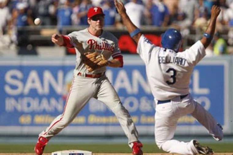 Chase Utley makes the force on Ronnie Belliard but throws the ball away allowing Juan Pierre to score the tying run in the eight inning. ( Ron Cortes / Staff Photographer )