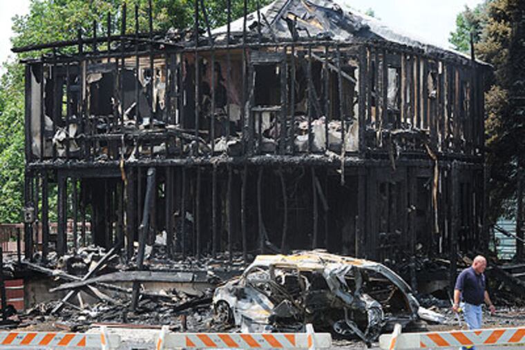 The charred remnants of a home at 3150 Byberry Road in Upper Moreland Township. A car crash, that killed the vehicle's occupants, sparked the blaze Tuesday. (Sarah J. Glover / Staff Photographer)