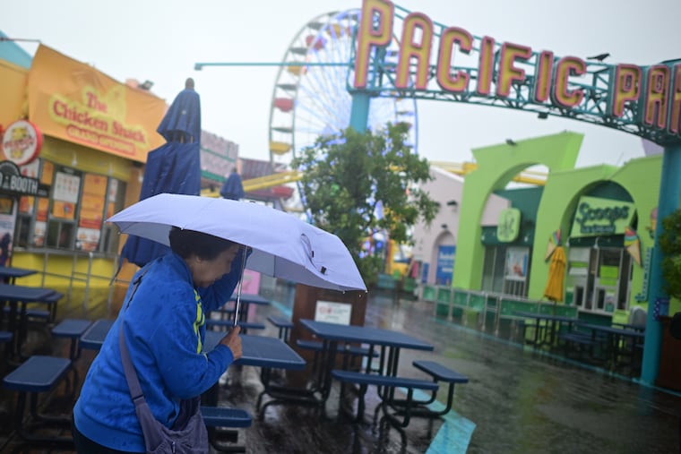 A tourist from China battles the rain Wednesday on the Santa Monica Pier.