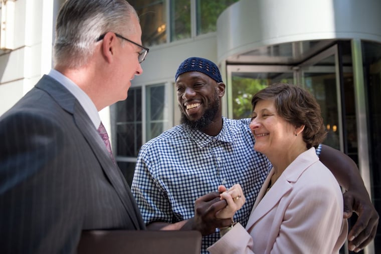 Shaurn Thomas, embracing Attorney Marissa Bluestine of the Pennsylvania Innocence Project, speaks with his lawyer James Figorski at the Criminal Justice Center in Center City on June 13th, 2017.