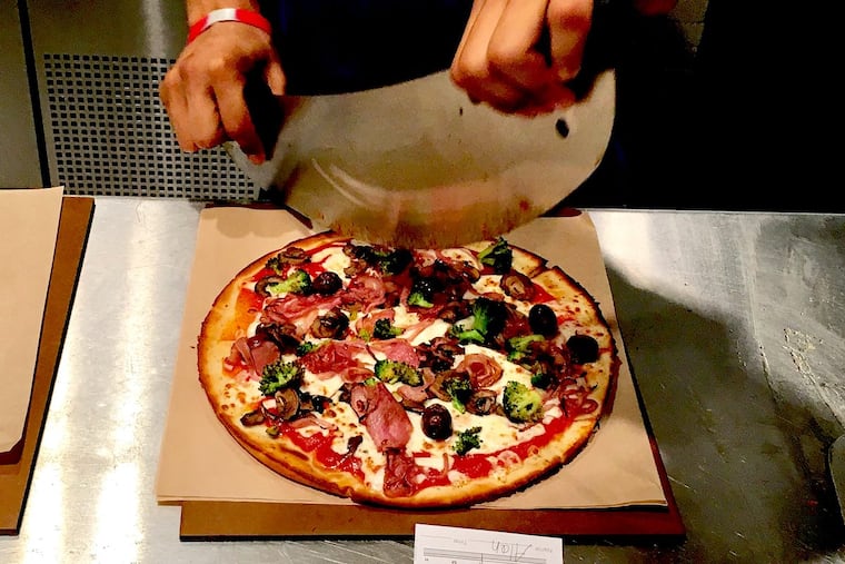 A pizza is about to be cut at Snap Custom Pizza.