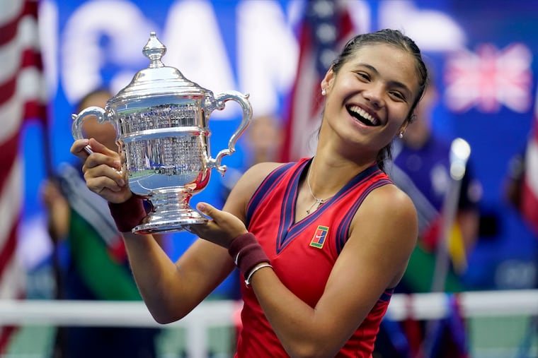 Emma Raducanu of Britain holds up the U.S. Open women's championship trophy after defeating Leylah Fernandez of Canada in the final.