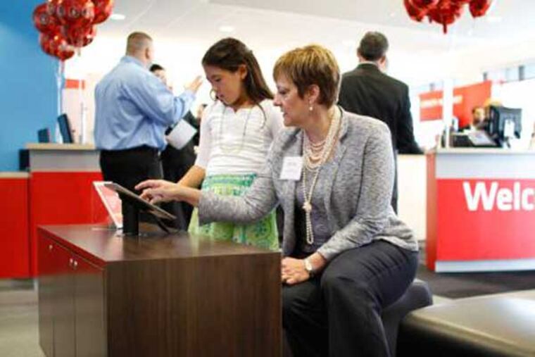 Comcast Regional Senior Vice President LeAnn Talbot demonstrates an Xfinity iPad app to Allison Goodman, 10, at the opening of the new Xfinity store in the Oxford Valley Plaza in Langhorne Pa., on Thursday April 26, 2012. (Comcast Photo / Joseph Kaczmarek)
