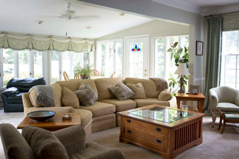 The living room , where upholstered couches and chairs fill a naturally lit space. ED HILLE / Staff Photographer