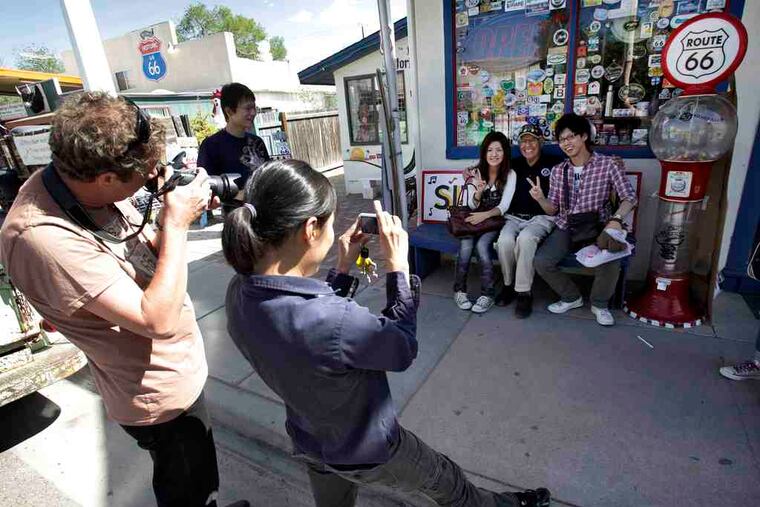 Angel Delgadillo poses for pictures with fans outside his souvenir store in Seligman, Ariz. "They just don't happen upon Seligman because they got lost and got off the freeway. They're here for a reason," says daughter Mirna. "And that reason is to see my dad." The 84-year-old retired barber never tires of telling his life story, which revolves around his beloved Route 66.
