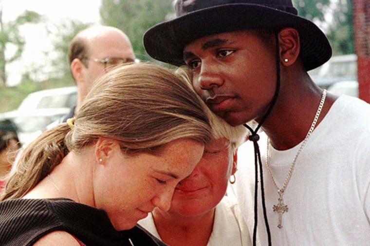 Slain athlete Aimee Willard's mother, Gail Willard (center), is embraced by Jason Culler (right) and a friend, Sunday, Sept. 13, 1998 in Philadelphia at the site where Aimee's body was found. (AP Photo/Jon Adams)
