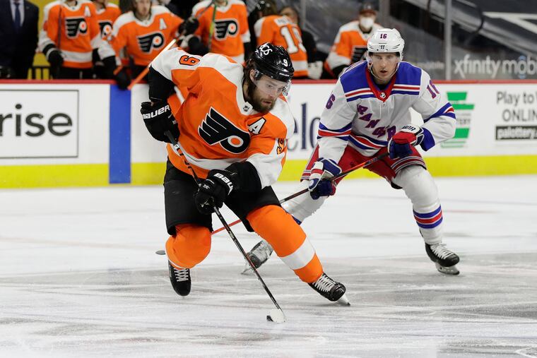 Flyers defenseman Ivan Provorov skates with the puck past New York Rangers center Ryan Strome.