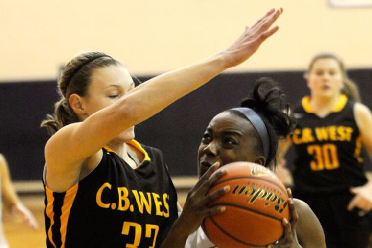 West Chester Rustin's Noelle Powell, right drives to the basket against Central Bucks West's Nicole Munger, left in the first half of the girls basketball game Friday, Dec. 6, 2013 in West Chester, PA (Bradley C Bower/Staff Photographer)