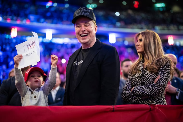 Elon Musk and Melania Trump (right) listen as Donald Trump speaks at a campaign rally in October.