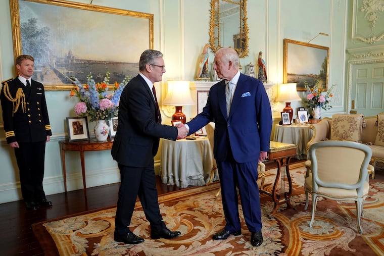 Britain's King Charles III, right, shakes hands with Keir Starmer, the new prime minister of the United Kingdom.