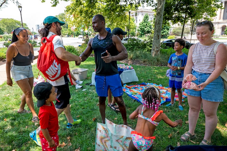 Mark Tomlin (center) greets Brendan Baldwin (left) while friend Hannah Weiss (right) gives a (hand-knitted) present to the birthday girl. Mom Natasha Silver is at left. Baldwin’s wife Cecelia is behind him. Their son Banks s in front left. Trinity’s older brother “M.J.” is in rear.
