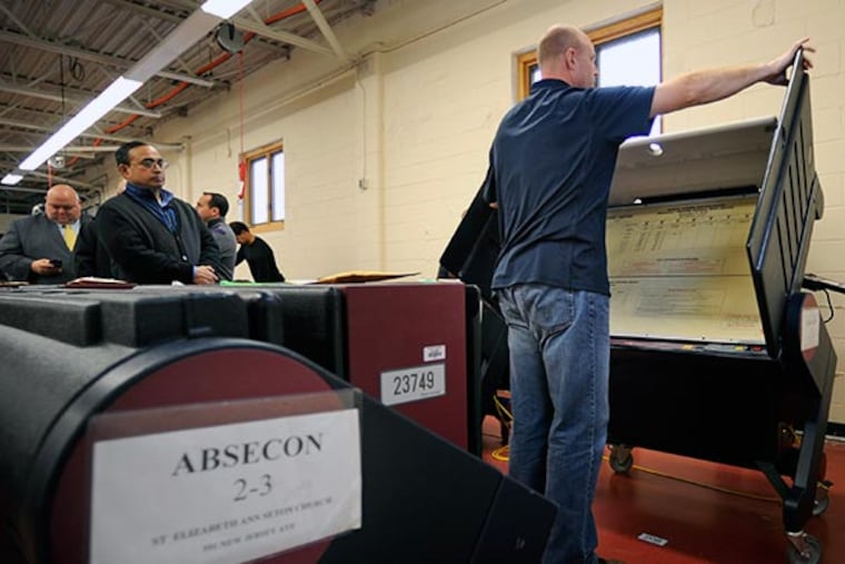 Ted Shober, the Board of Elections Voting Machine Warehouse manager, opens a machine November 26, 2013 as a second recount is underway in the Second District Legislative Race. Board of Elections commissioners are going through all 208 machines used in the election, pulling the tape of each and announcing out loud how many votes were cast per machine to compare with the election night results. ( TOM GRALISH / Staff Photographer )