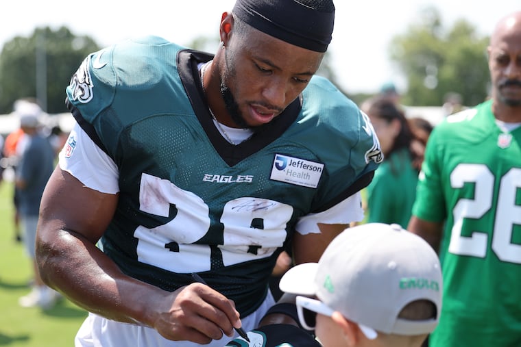 Eagles running back Saquon Barkley signs autographs after a training camp practice on Sunday.