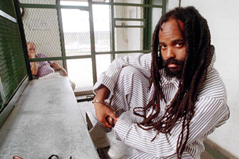 In a 1995 photo, Mumia Abu-Jamal is shown during an interview on death row at Graterford Prison in Pennsylvania. (April Saul / Staff Photographer)