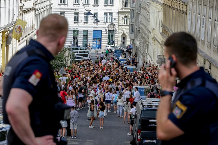 Austrian police officers watch fans gathering in Vienna for a Taylor Swift concert on Aug.8, 2024.