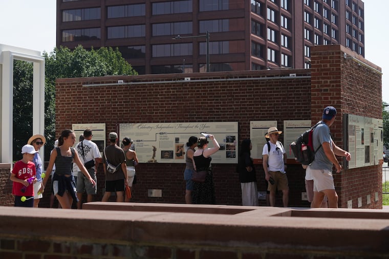 Visitors to the President's House site, where new panels have been installed. Historians and advocates have criticized the panels for minimizing Washington's role as an enslaver.