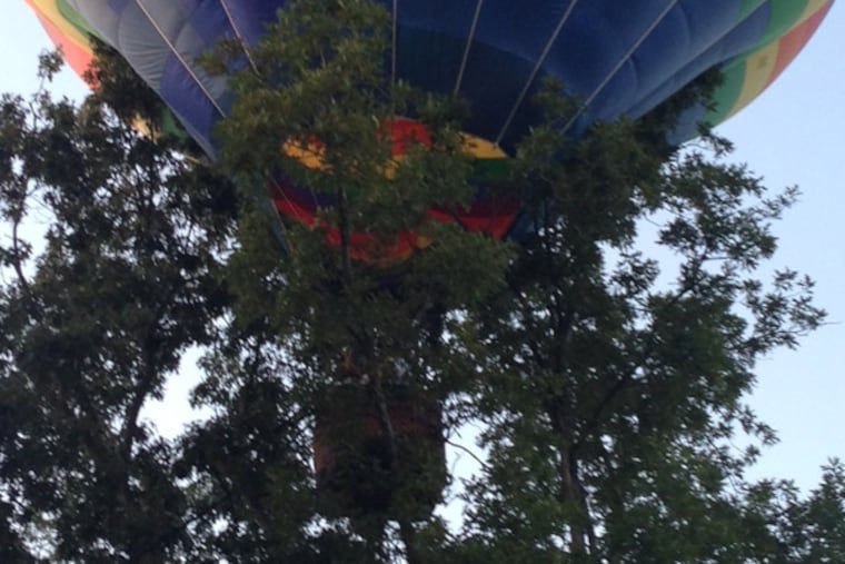 A hot air balloon carrying two children got stuck in the treetops in Gloucester Township, N.J., on Aug. 15, 2013. The pilot managed to free the balloon and land it safely.