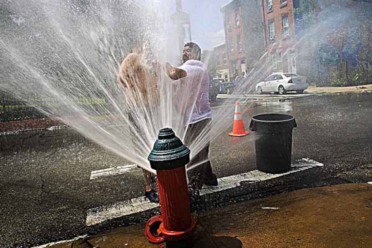 In the hydrant are Jose Candelaria and Hector Colon (right) as they cool off from the high temperatures on Tuesday afternoon. ( ALEJANDRO A. ALVAREZ / STAFF PHOTOGRAPHER )