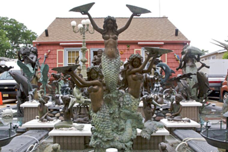 Twins Gerald and John Hubbs, 59, have a front yard with 30 bronze figures, mainly whimsical sea themes, plus a few children, geese and horses. ( John Costello / Inquirer )