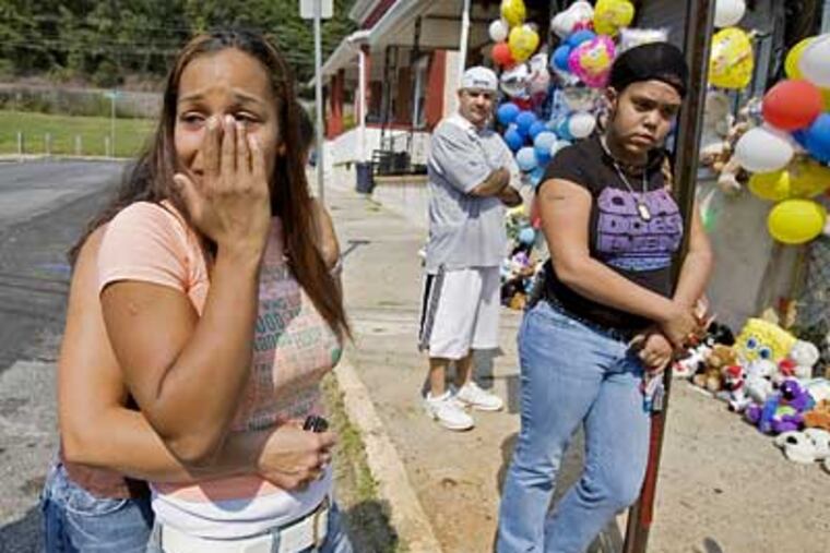 Jessica Torres, left, mother of Coatesville fire victims Tyzhier and Tyrone Hill, weeps outside her home as she is comforted by friends and family. (Ed Hille / Inquirer)