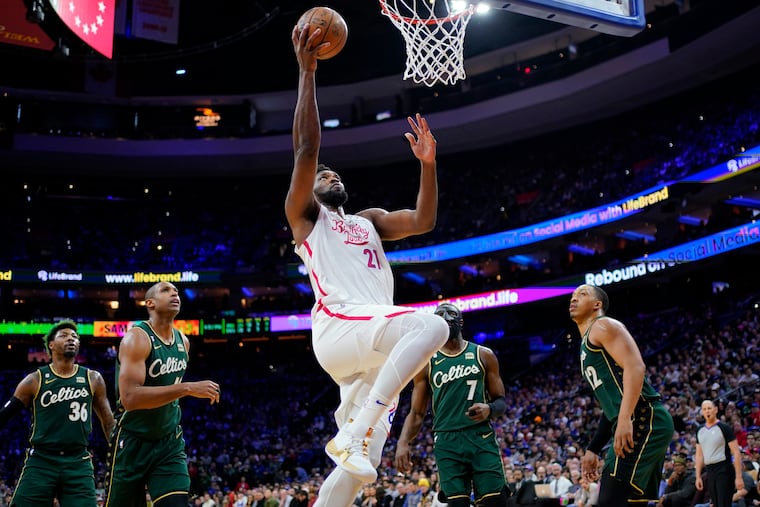 Joel Embiid (21) goes up for a shot against the Celtics.