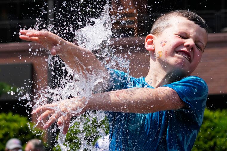 A boy cools off at a fountain outside Wrigley Field as hot weather descends upon the Chicago area on Sunday, June 16, 2024.