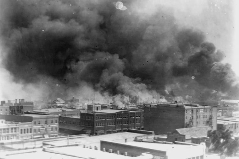 In this 1921 image provided by the Library of Congress, smoke billows over Tulsa, Okla. An Oklahoma judge has thrown out a lawsuit seeking reparations for the 1921 Tulsa Race Massacre.