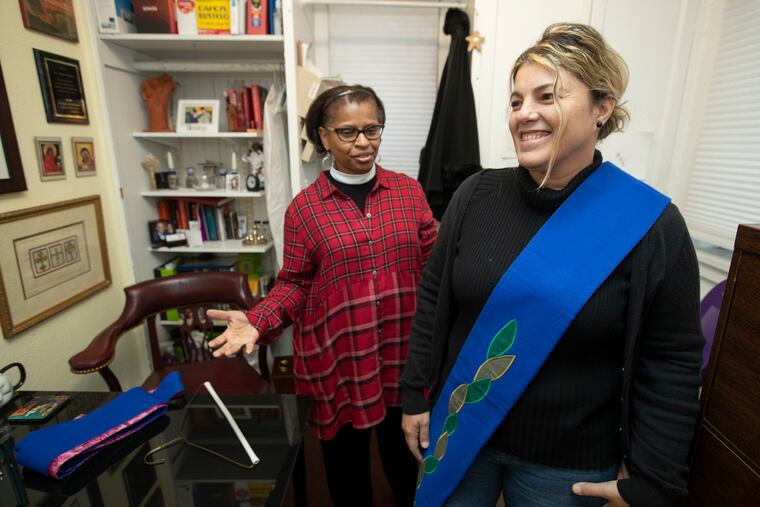 Jessie Alejandro, right, practices placing the vestment in preparation for her Saturday ordination with her mentor, the Rev. Deirdre Whitfield of St. Mary’s Episcopal Church.